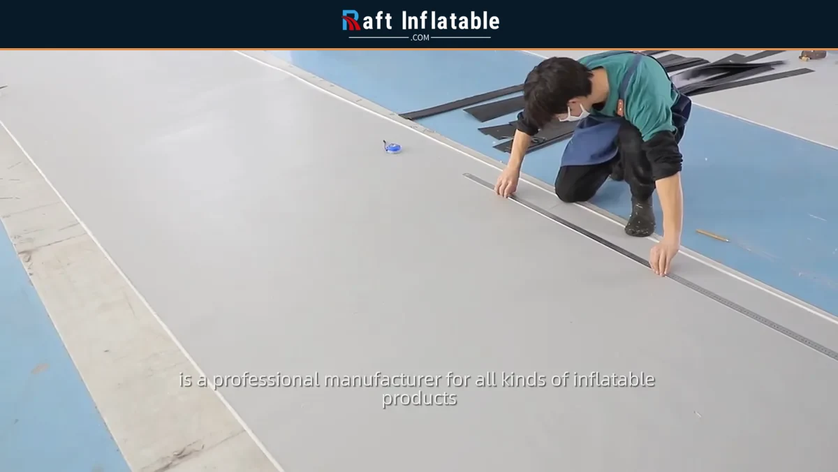 Worker measuring and marking inflatable boat material on a cutting table