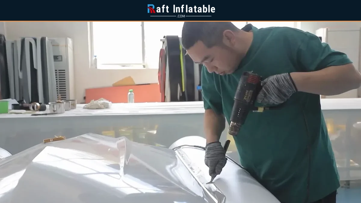 Worker using a heat tool during inflatable tube assembly